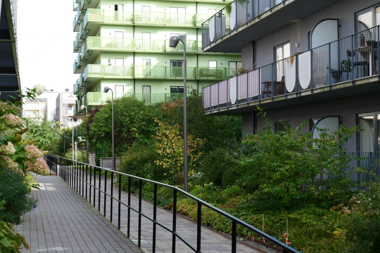 several balconies on the side of a building, one on the second floor with a window above a balcony with plants