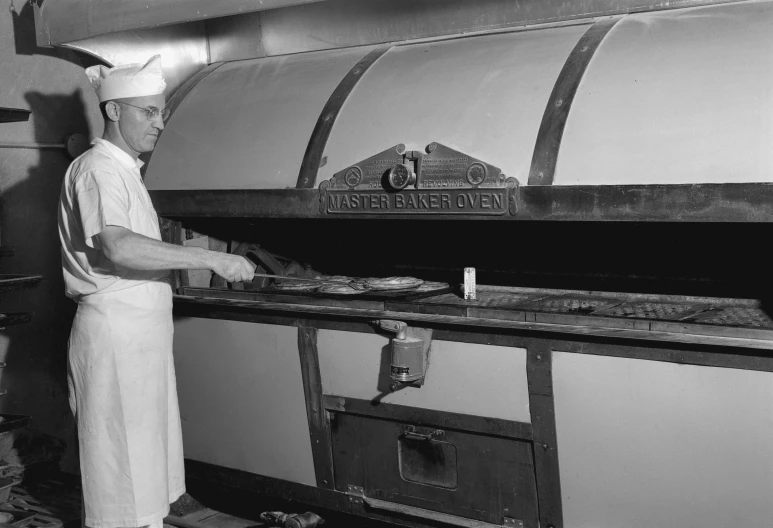 a chef stands in front of a pizza oven