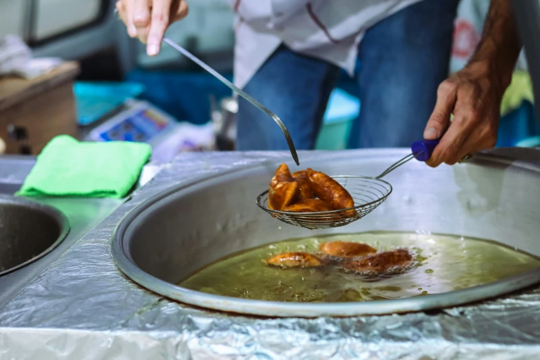 a woman is putting fried food in a large bowl