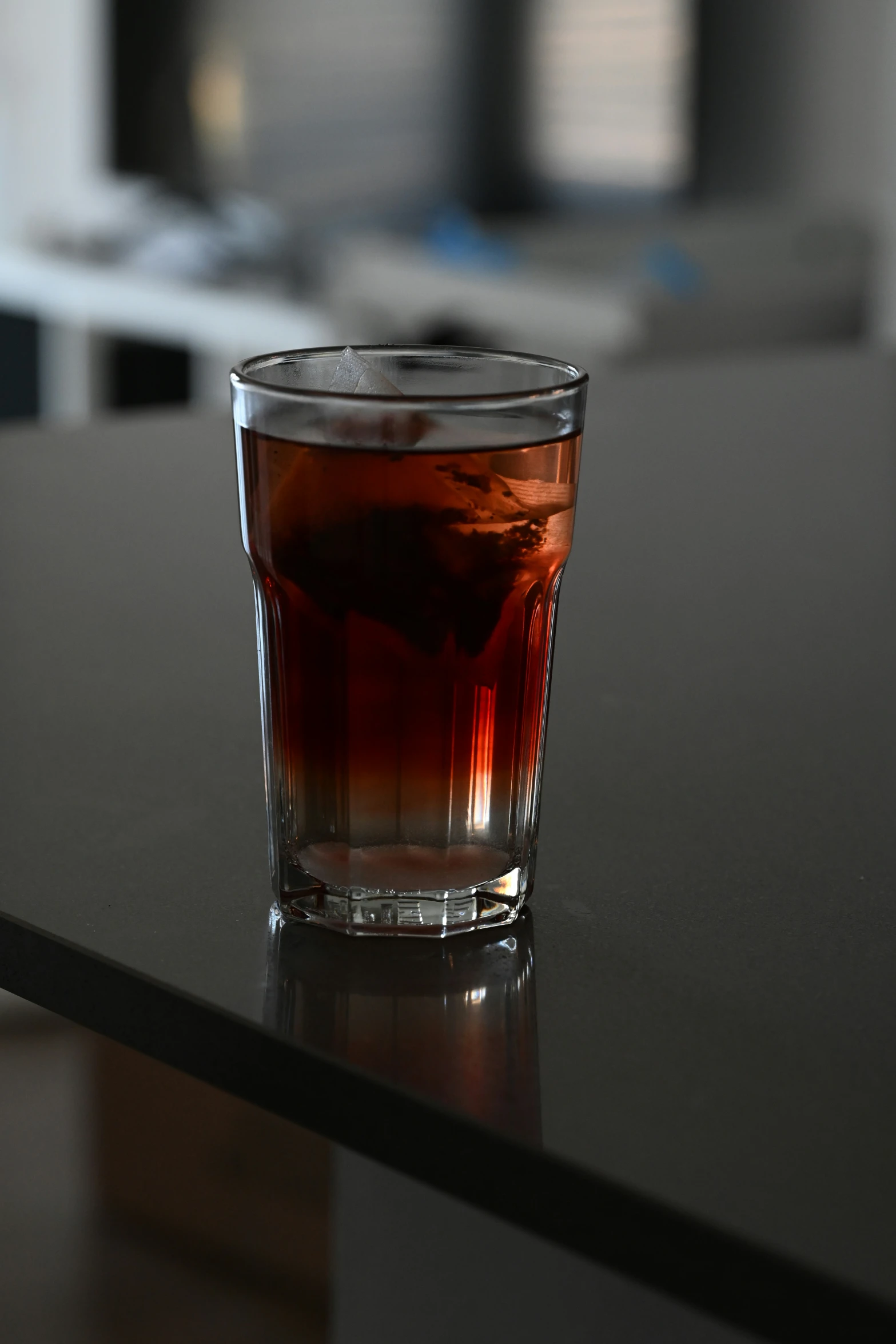 a glass of beverage sitting on a table