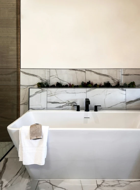 white marble tile and walls are accented with black and grey fixtures