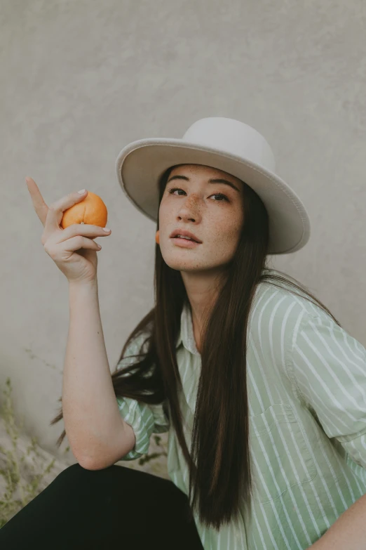 a girl is holding two oranges on the left
