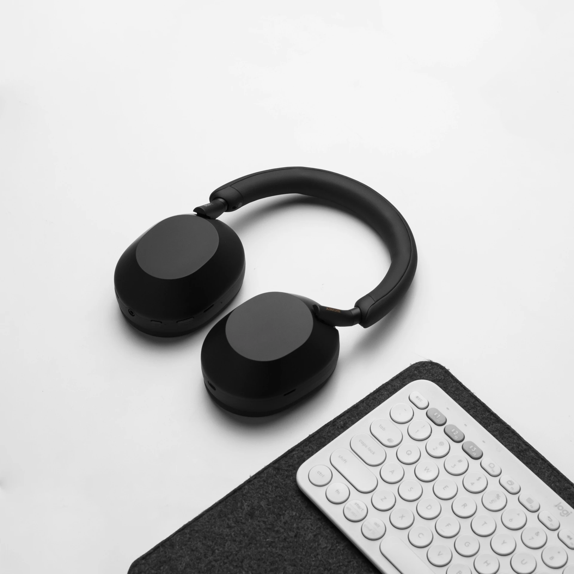 the black headphones are laying on top of the computer keyboard