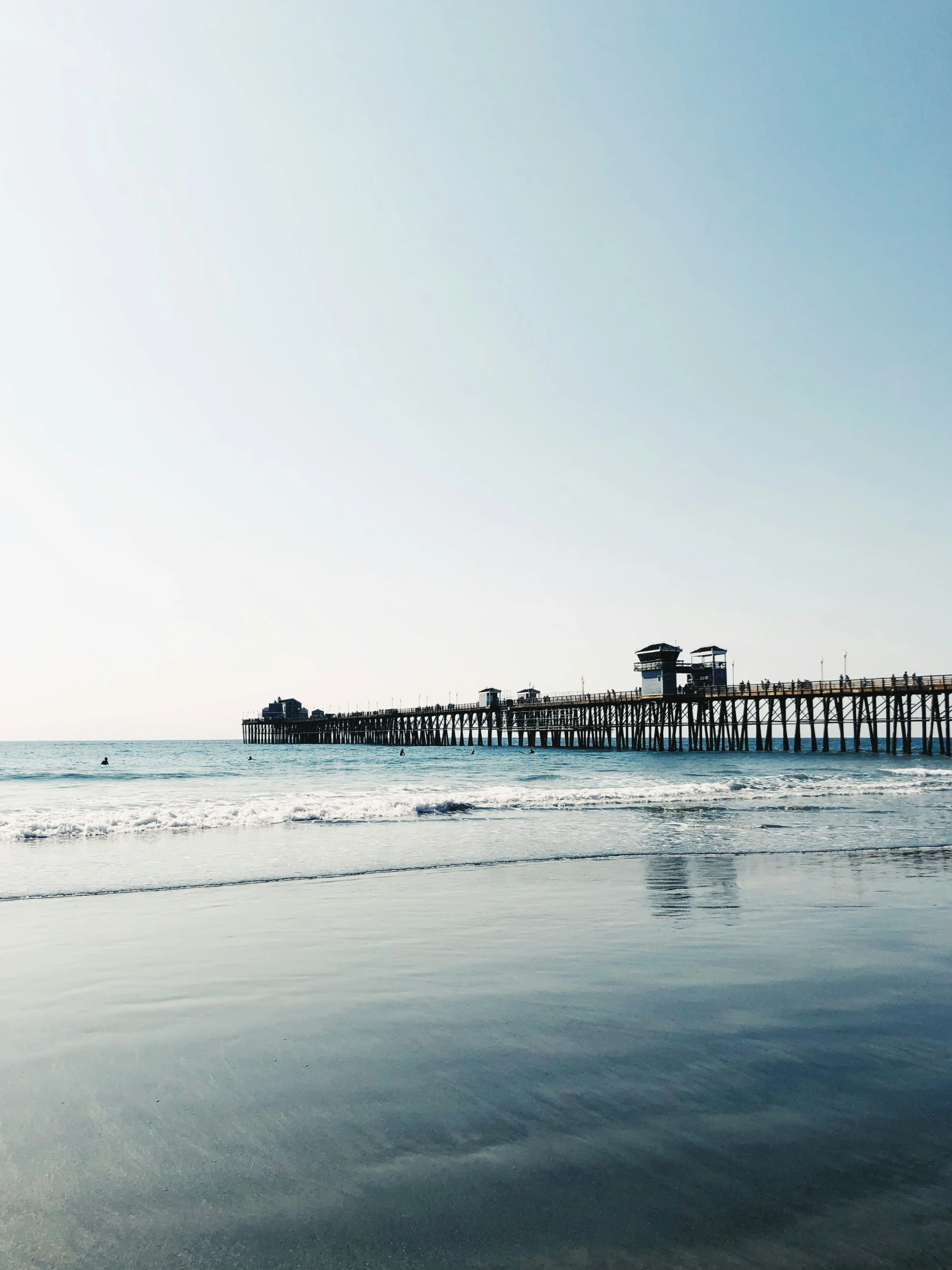 an empty beach with a dock sitting on the end of it