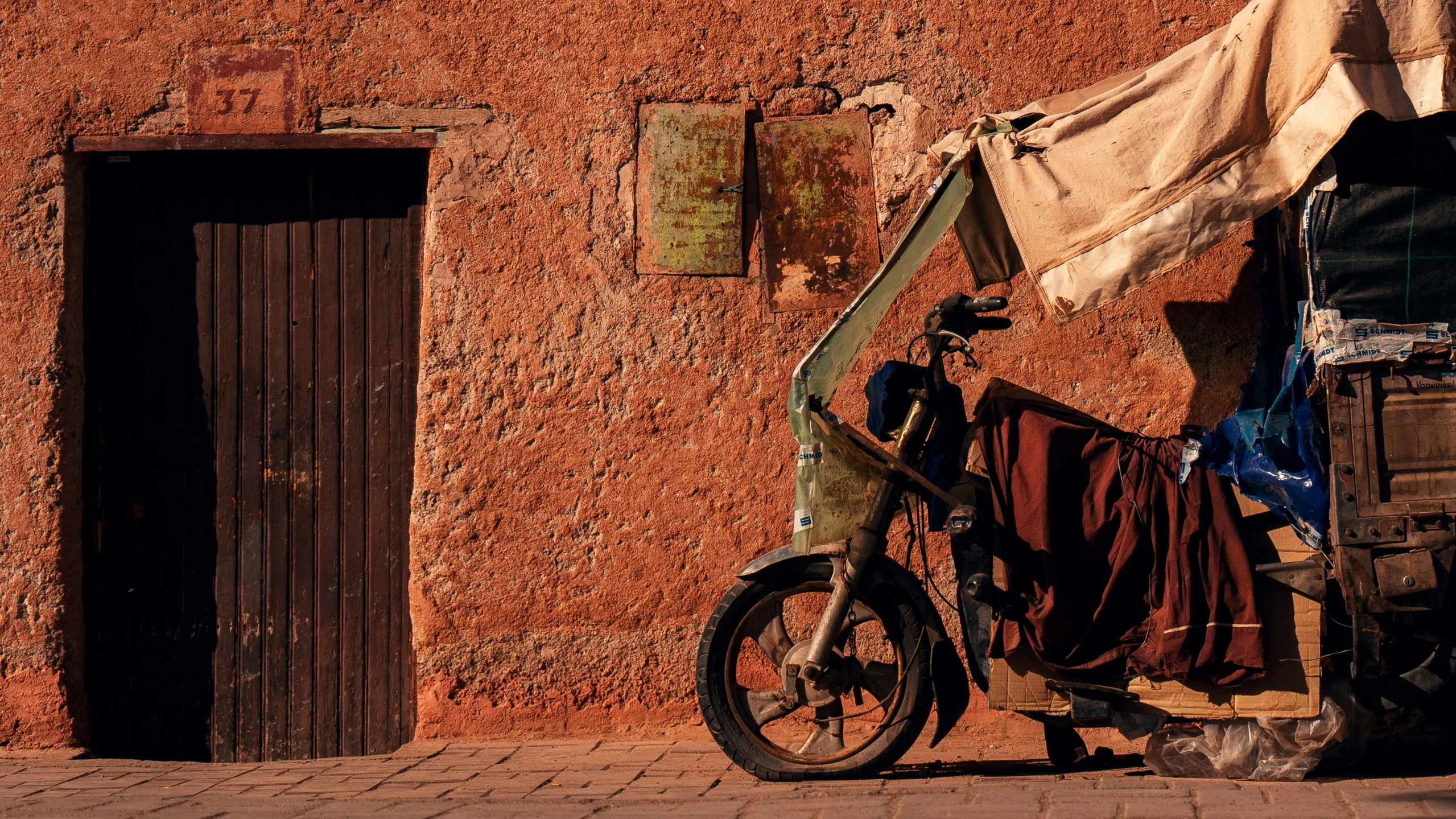 a bike parked against a building next to a sheet