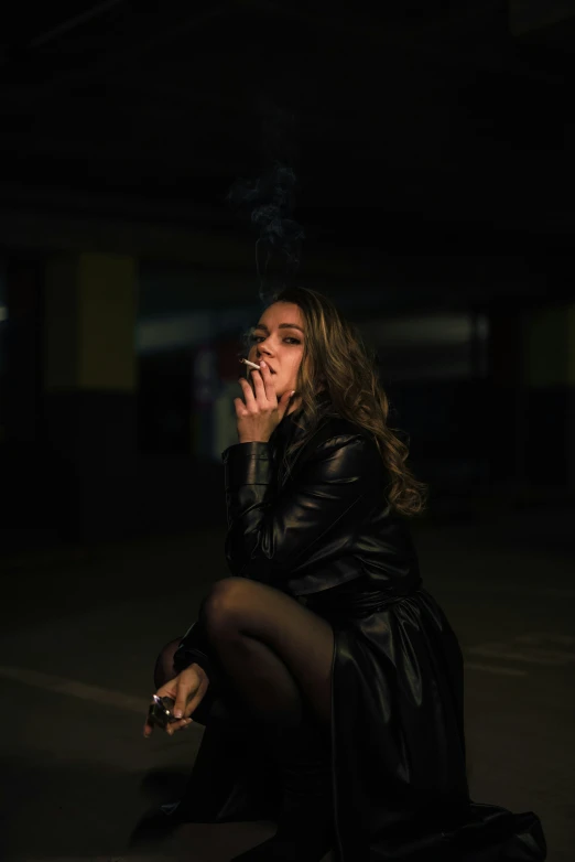 a woman is smoking a cigarette in the dark