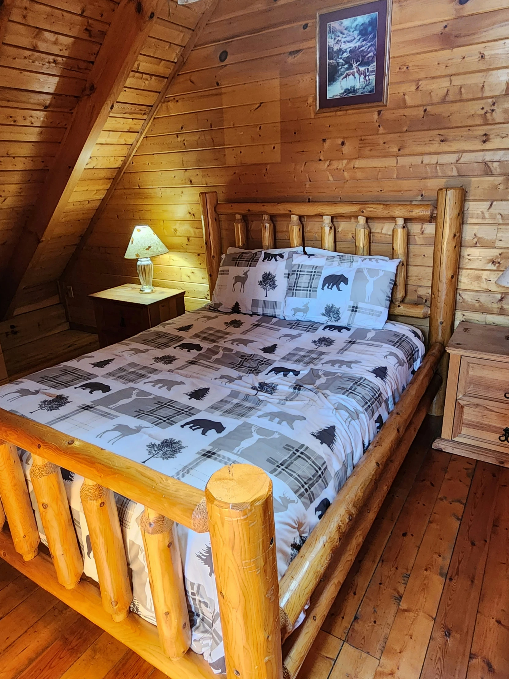 a bedroom with wooden walls and wood floors