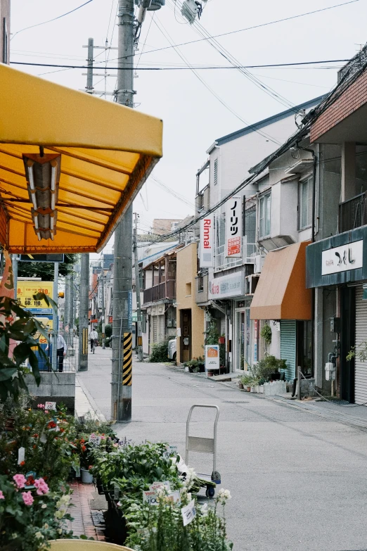 a few buildings on a small street with a bench and chairs