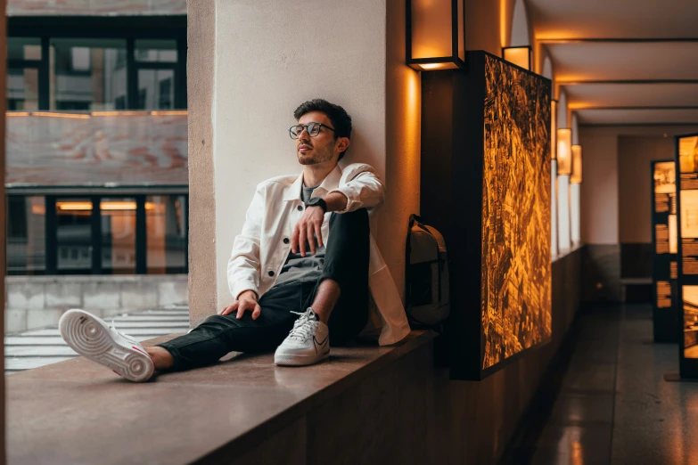 a man sitting on the ledge of a window sill with his foot up