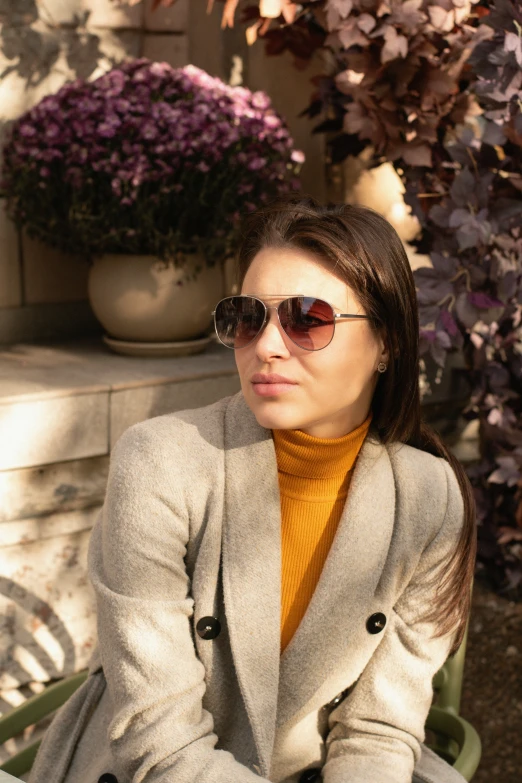 a woman with sunglasses on sitting next to a bench