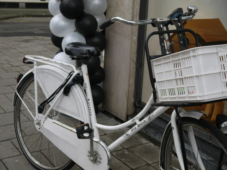 a bicycle that is parked with balloons on the back