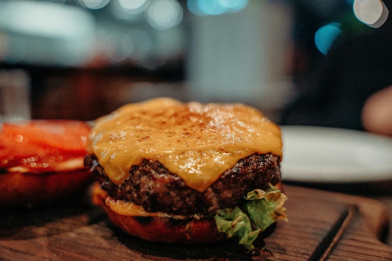 hamburger sitting on a board with other ingredients and toppings