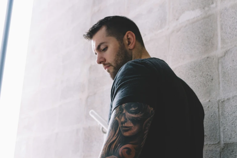 a man standing in front of a wall with his face painted on