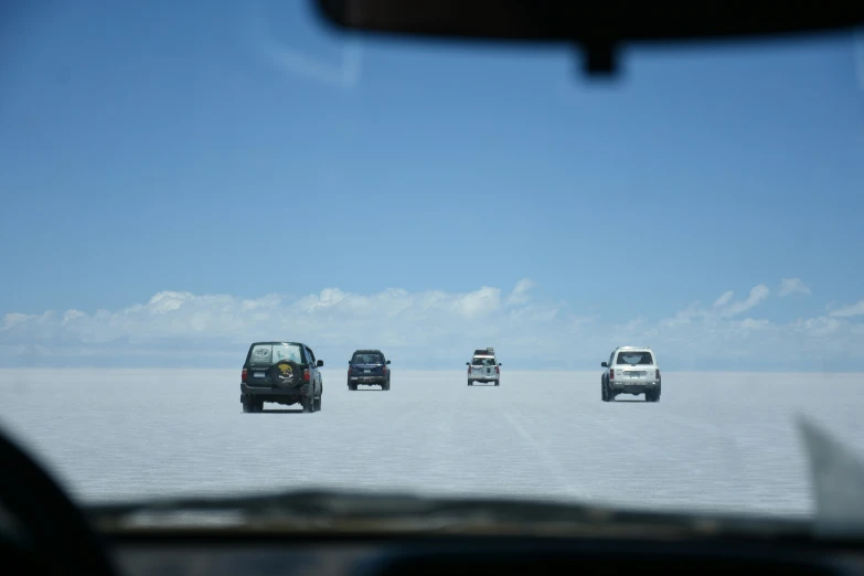 several vehicles in a line in an overcast sky