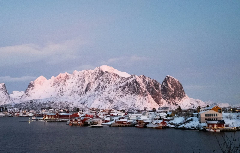 a scenic view of a city and snow capped mountains