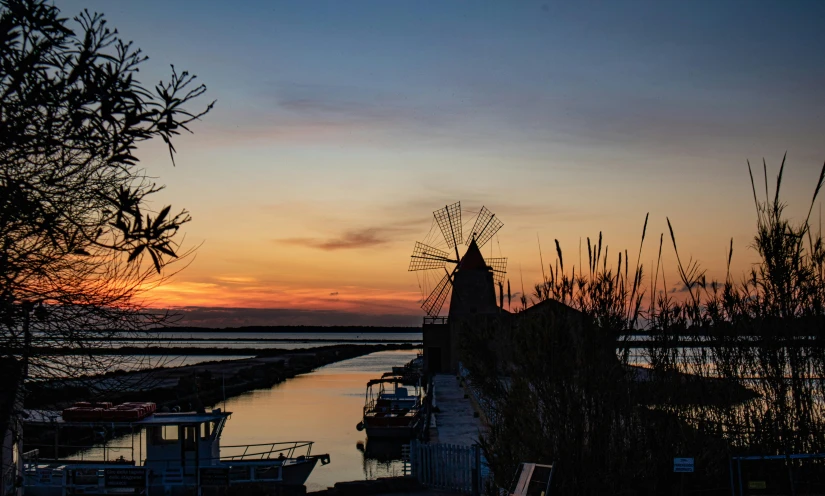 sunset over a canal with many boats