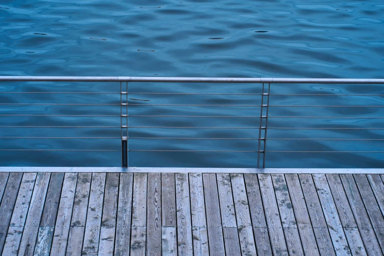 the deck extends from the blue water to the wooden deck