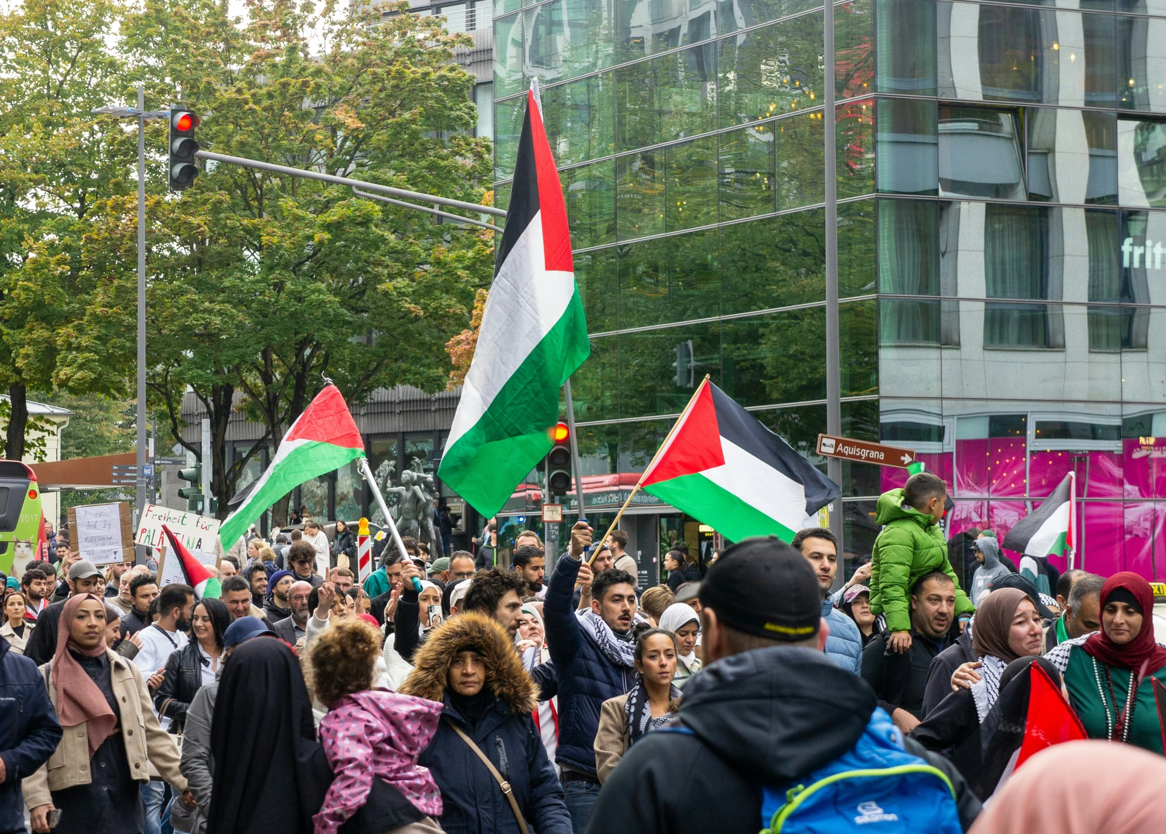 many people are holding flags and walking in a protest