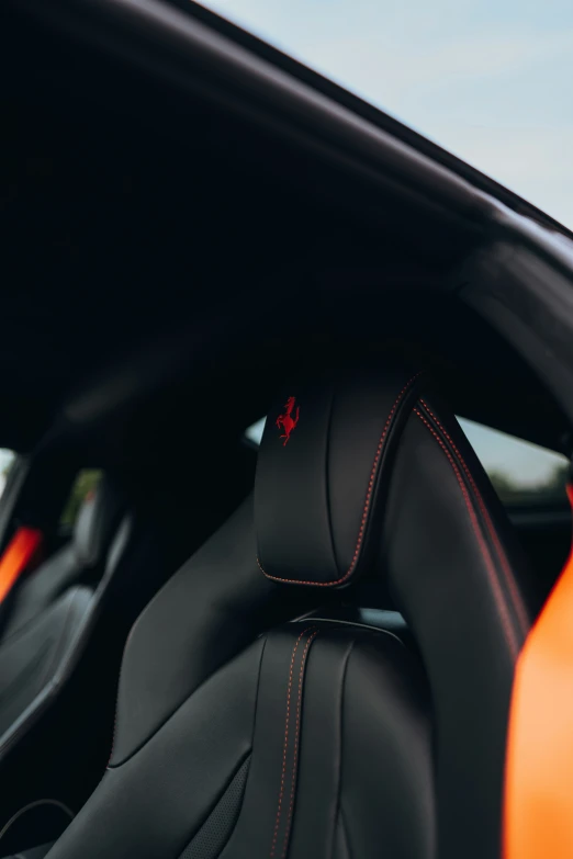 a view of the back seats of a black and orange sports car