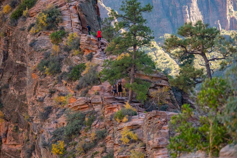 the two people are climbing up the cliff