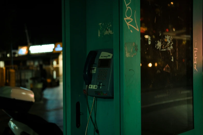 a phone is in a green box on the sidewalk