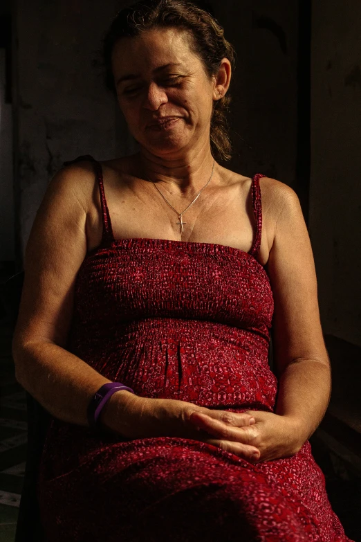 an old woman in a red dress sitting