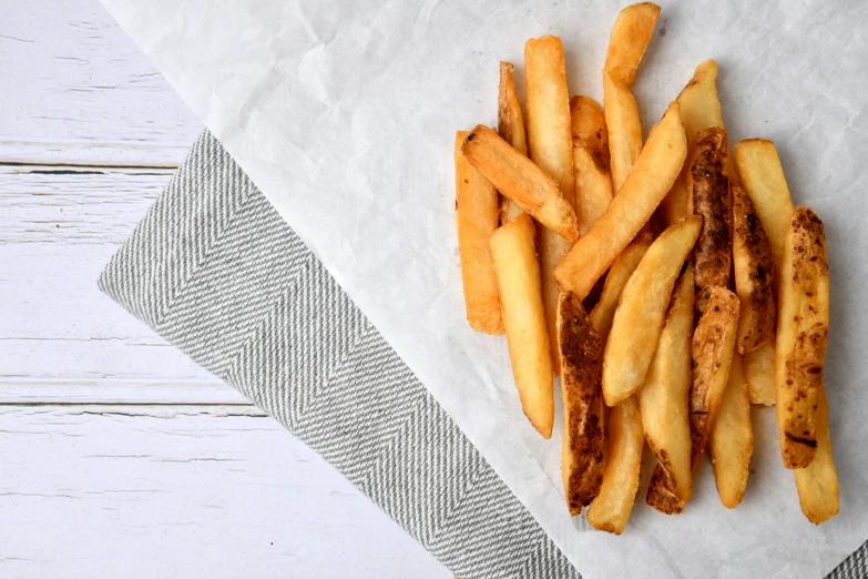 a pile of french fries on top of a white surface