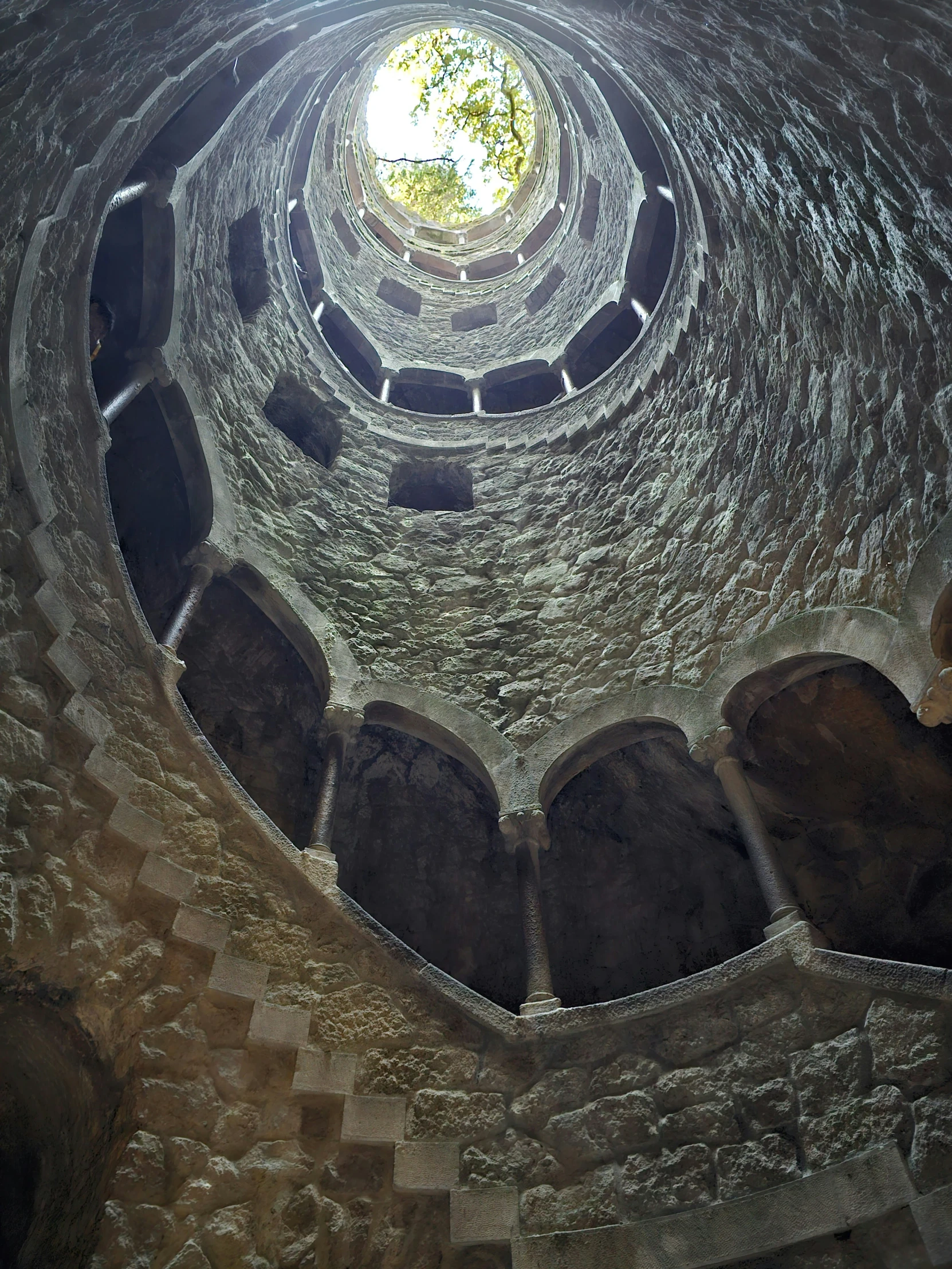 a spiral brick wall with a light at the top