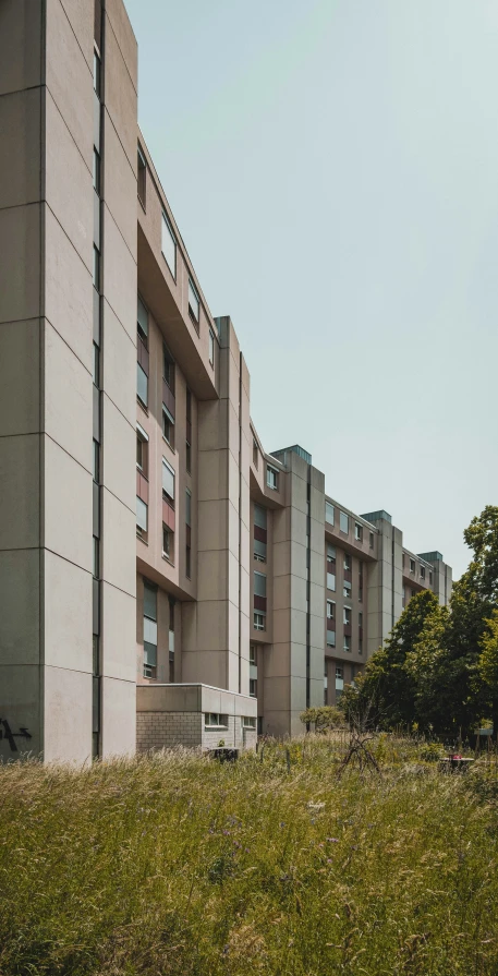 two tall buildings with multiple balconies and a bench in front