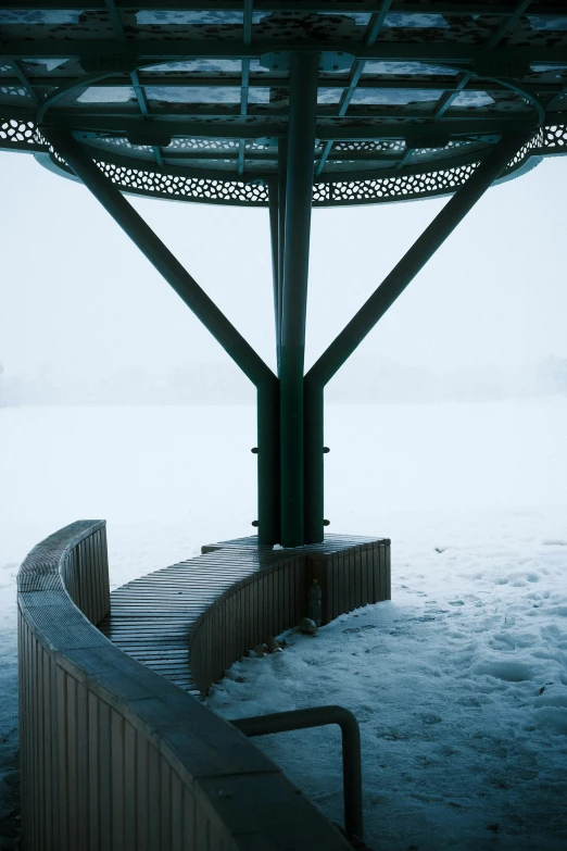 a bench on the edge of a platform in the snow