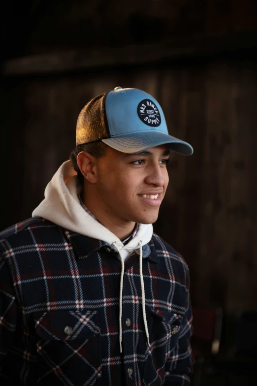 a man smiling wearing a hat with an emblem