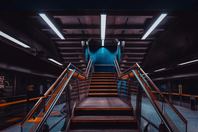 some blue stairs are shown with yellow hand rails