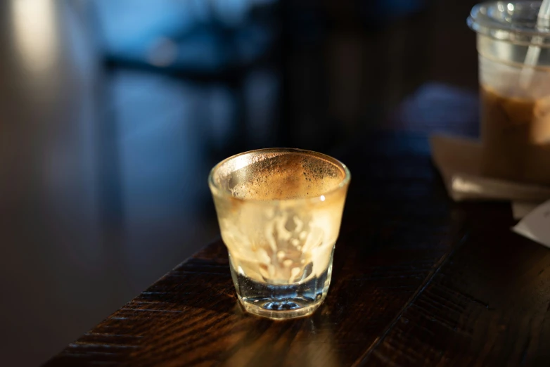 a glass is next to another glass on a table