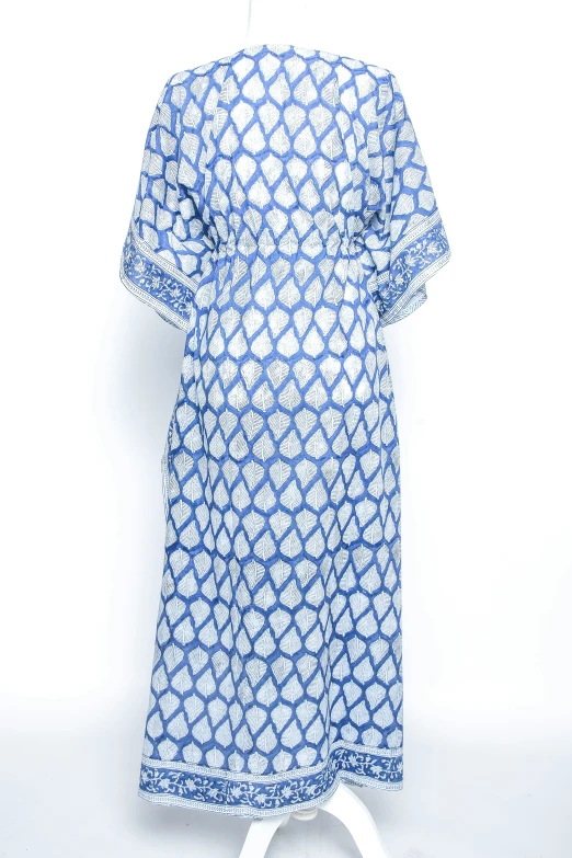 a white and blue dress with a print is hanging up on the clothes hanger