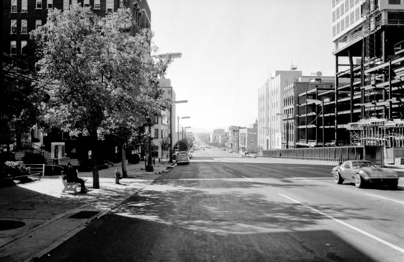 a deserted city street with tall buildings in the background