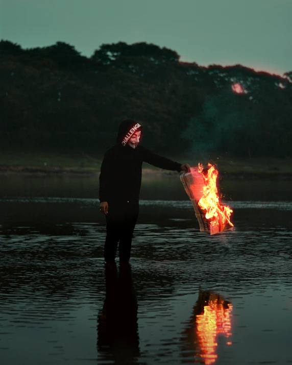 a person with a lit up mask next to a fire