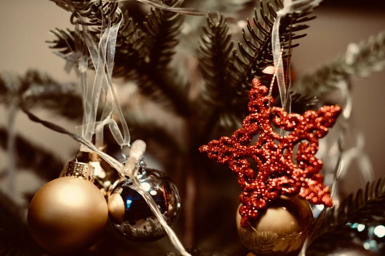 two small ornaments sitting on top of a tree