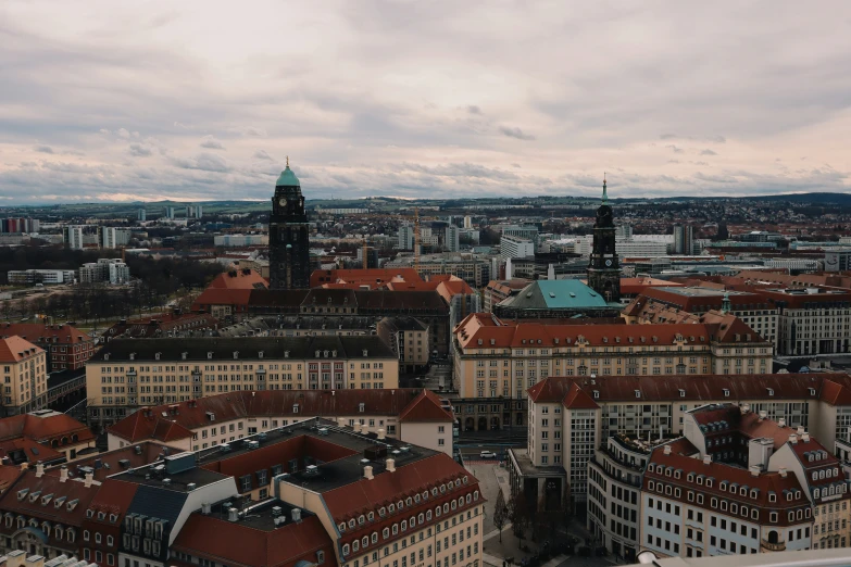 a very tall building sitting above a city filled with red roofs