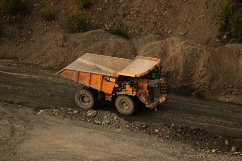 a truck with a tarp on it sits in the middle of dirt