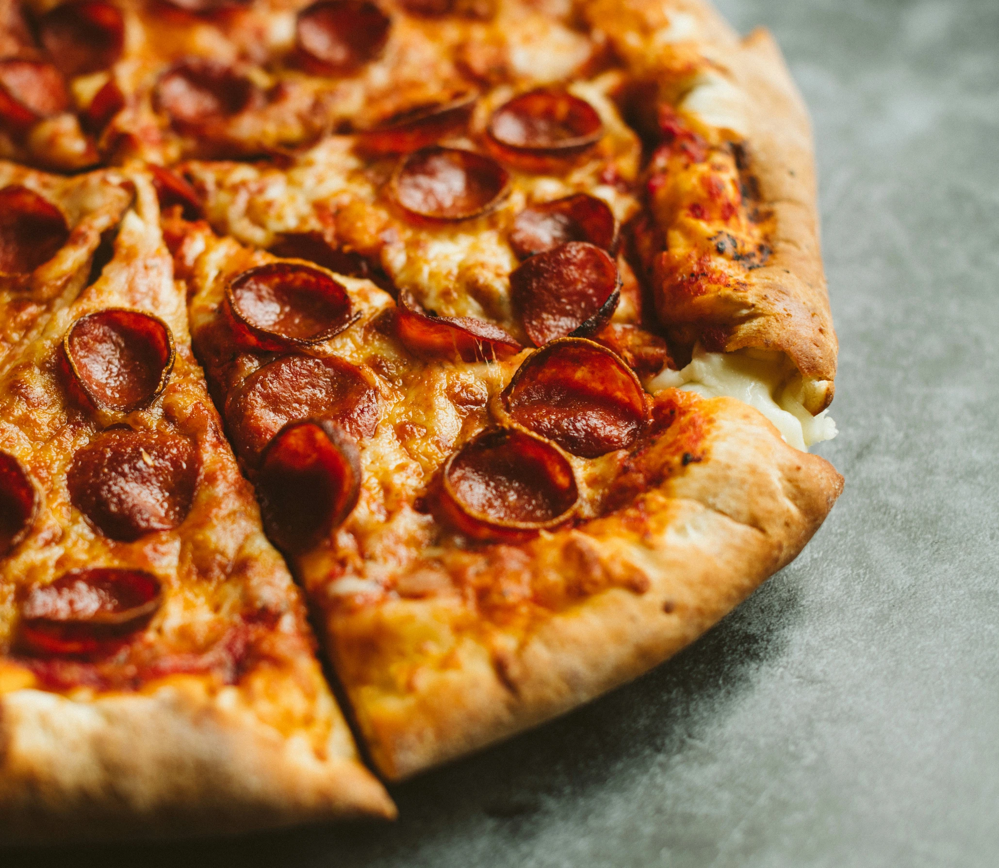 a pizza with pepperoni on top is laying on a pan