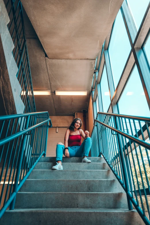 a woman sitting on the stairs looking down at her cell phone