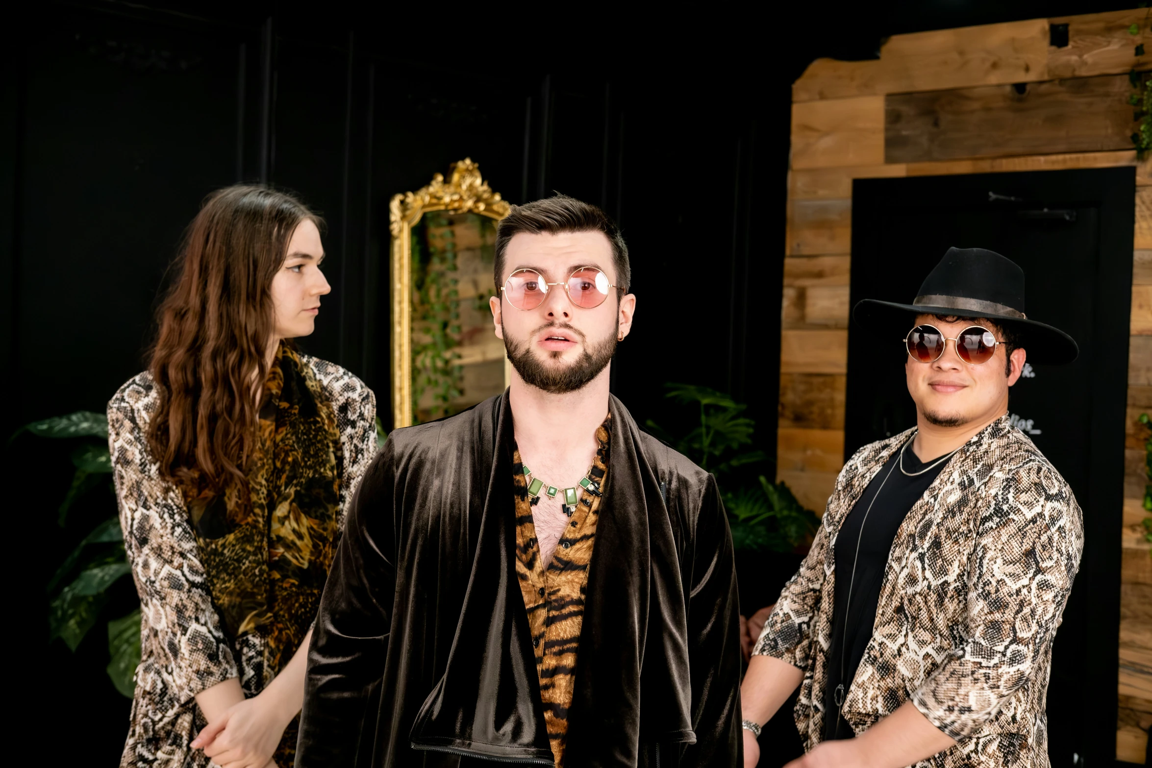 three people with hats and sunglasses looking at a wall