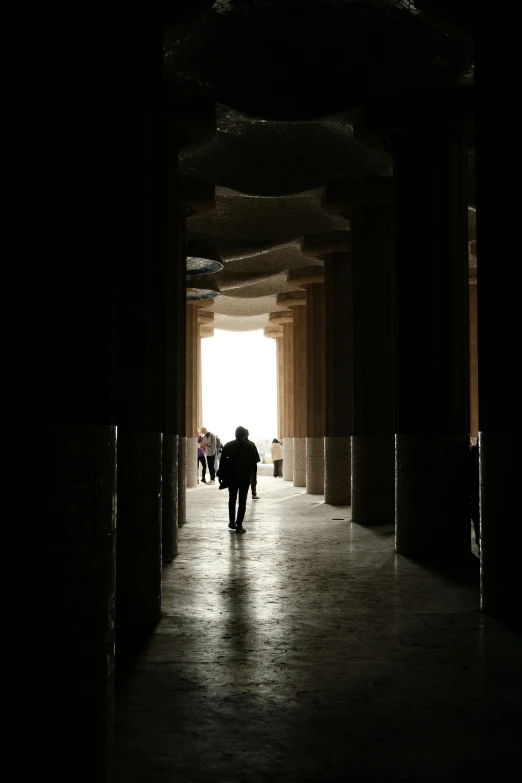 a person in a long hallway with pillars