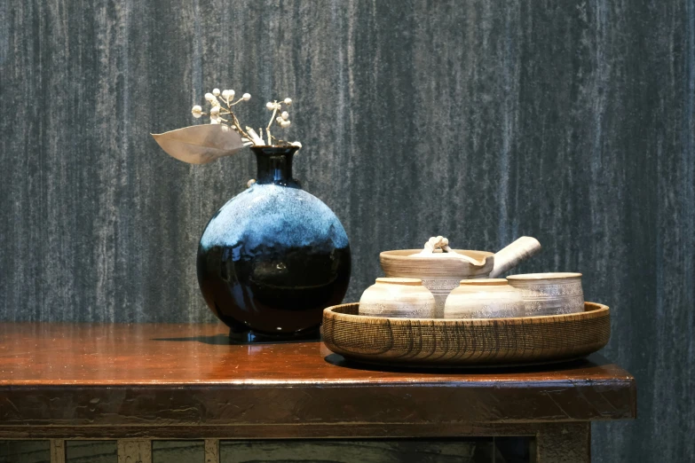 a wooden shelf with a vase, bowl and a bottle