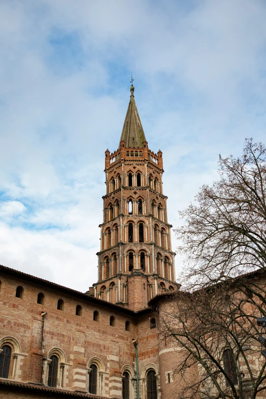 a tall tower with a pointy top stands in the city