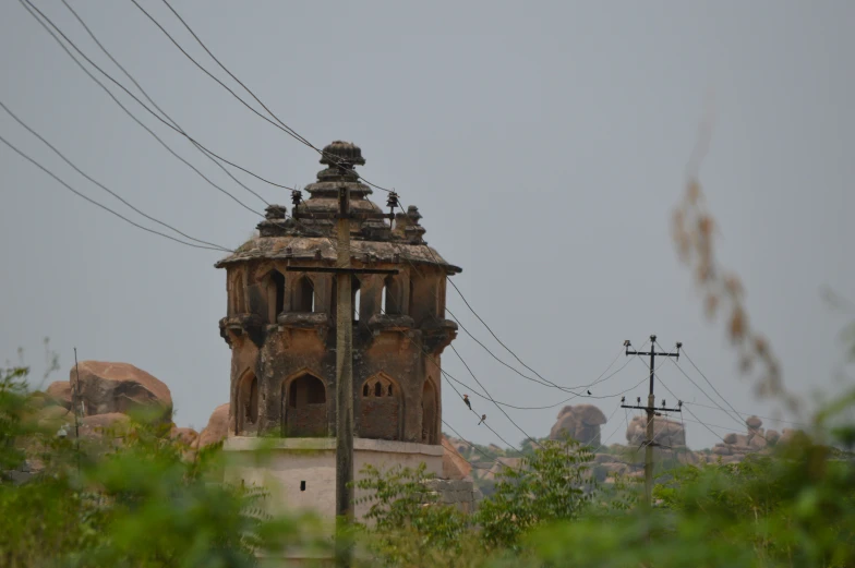 a very old clock tower with a power line behind it