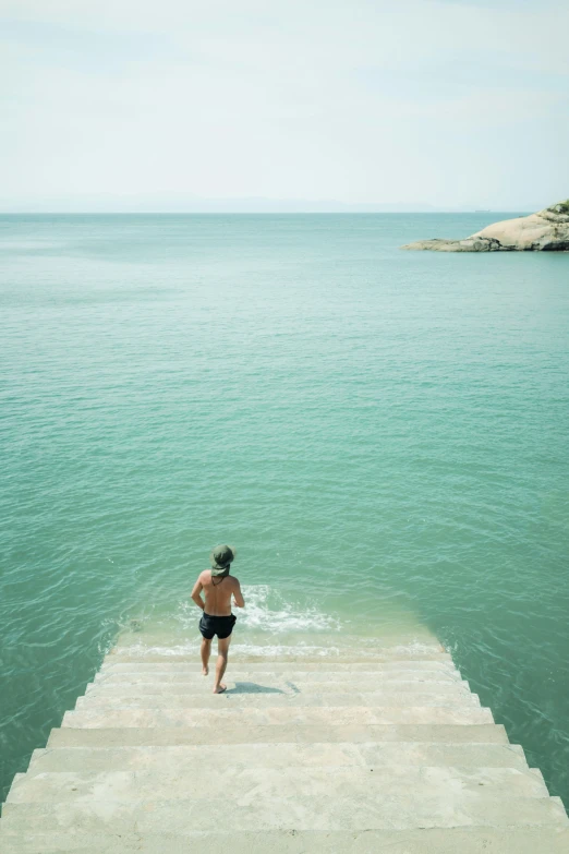 a person running down some steps into the water