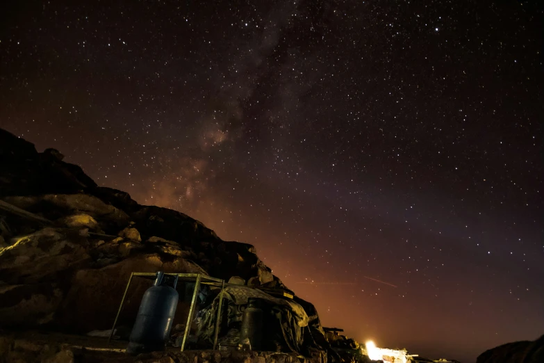 a large hill covered in trees and rocks under the stars