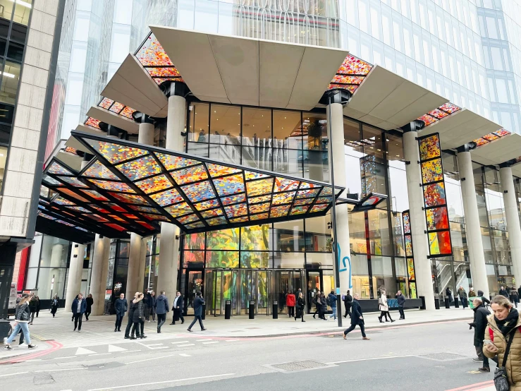 people walking down a street outside an open building