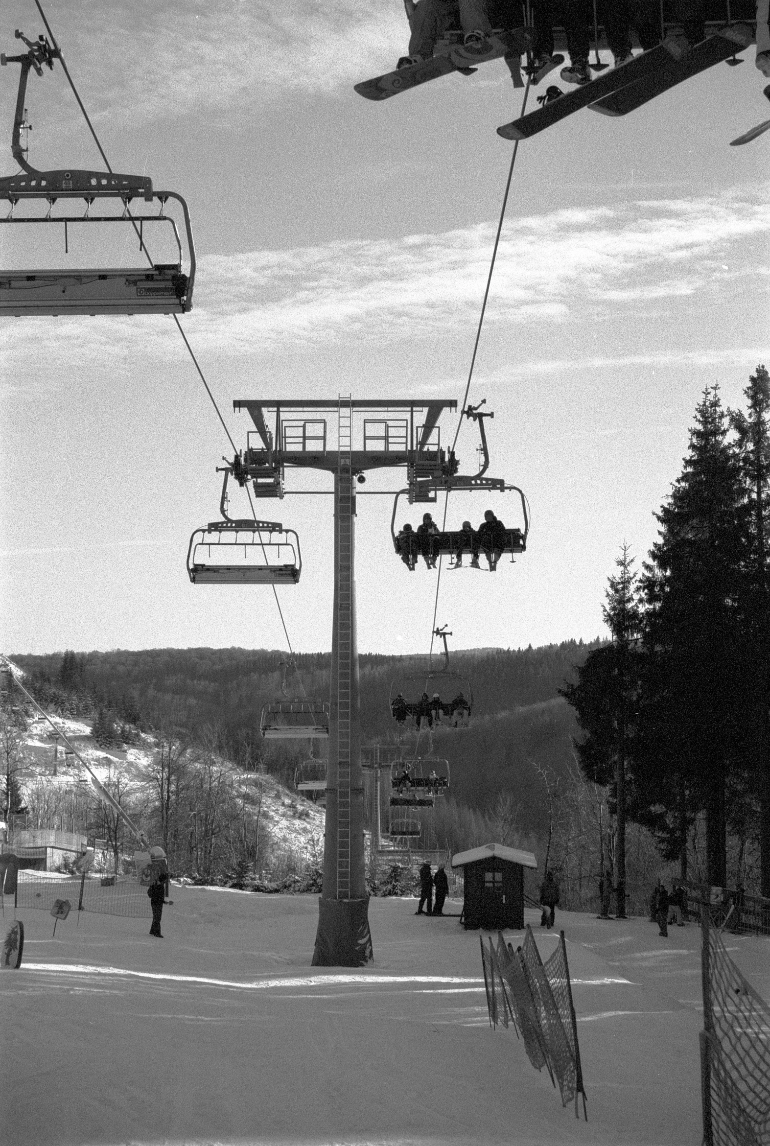 people are riding on a ski lift over a snowy hill